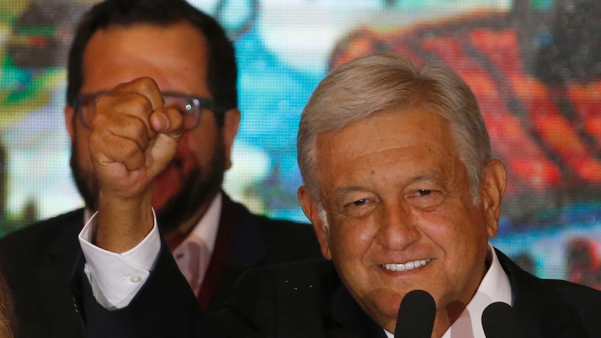 Presidential candidate Andres Manuel Lopez Obrador waves to supporters as he gives his first victory speech.