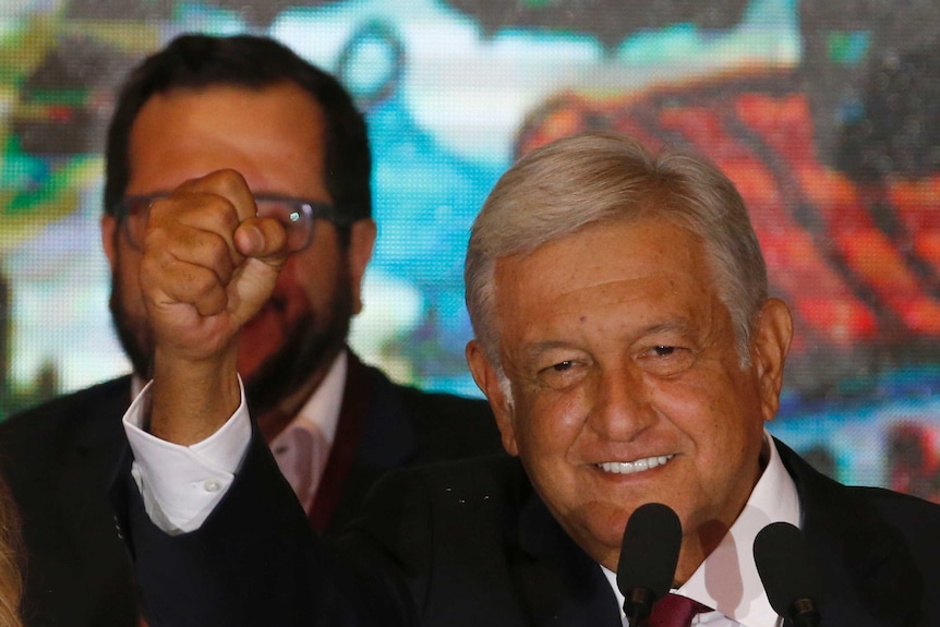 Presidential candidate Andres Manuel Lopez Obrador waves to supporters as he gives his first victory speech.