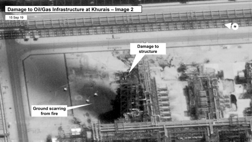 A black and white satellite image of a Saudi Arabian oil processing facility, with a charred mark in the centre of the image.