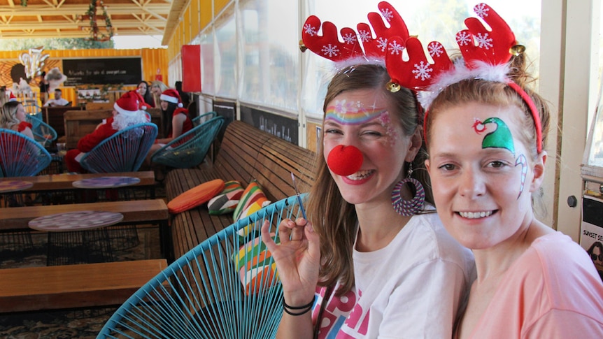 Two girls with antlers and face paint on them.