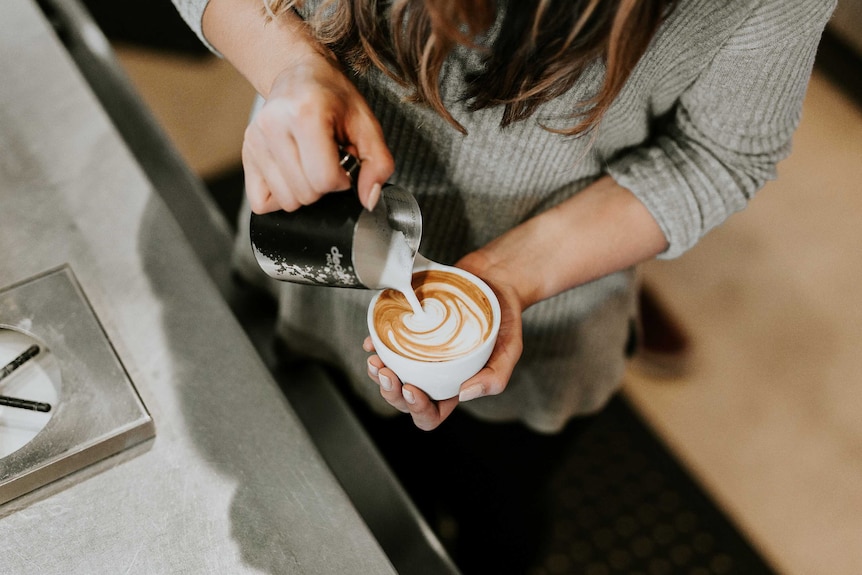 A woman pours a coffee.