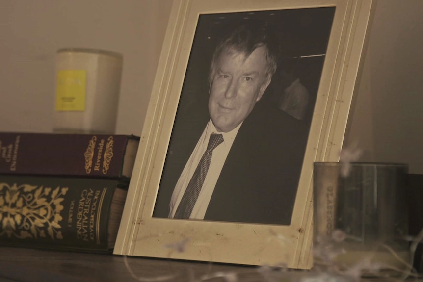A black and white photo in a frame on a bench of an older man who is Peter McNamara's father