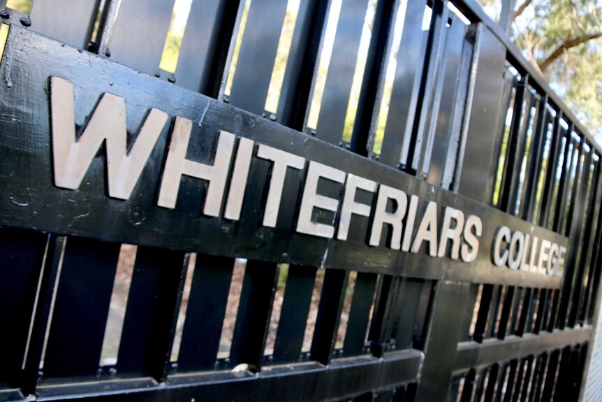 White lettering spells out 'Whitefriars College' across a closed black school gate.