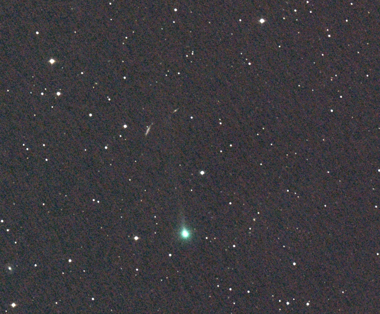 Black starfield with a faint green comet visible in the centre.