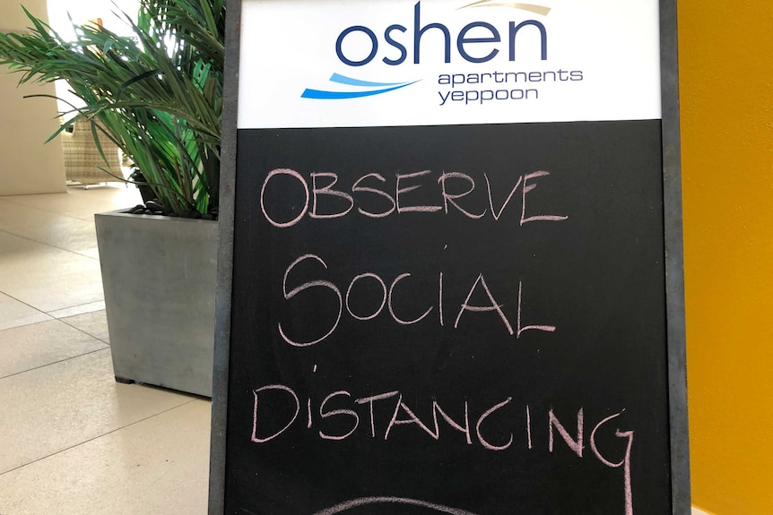 A sign reads observe social distancing at a hotel.