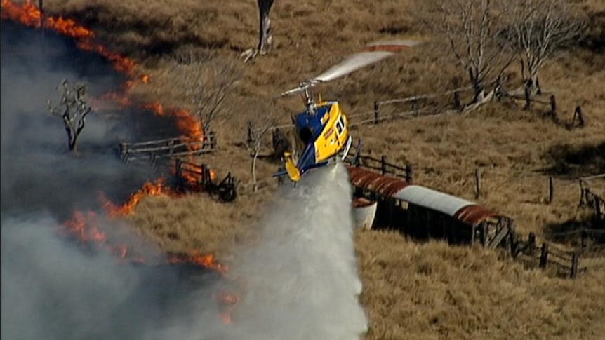 Water bombing helicopter fights grass fire
