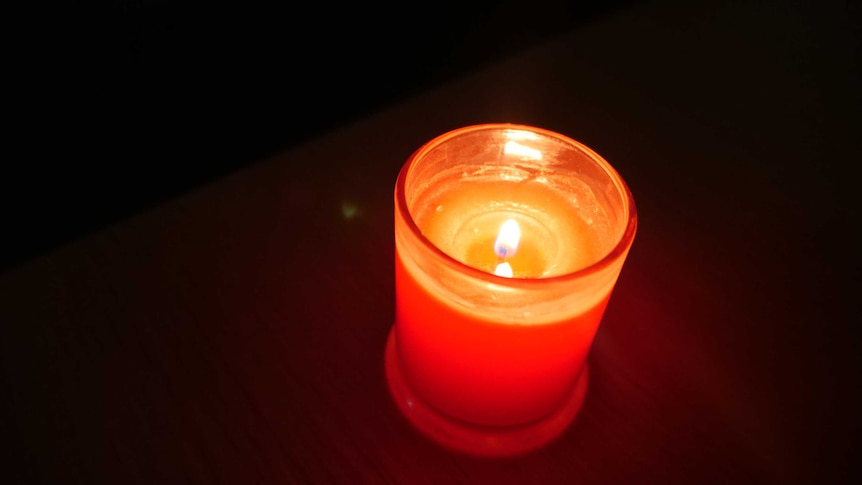 A red candle in a dark room.