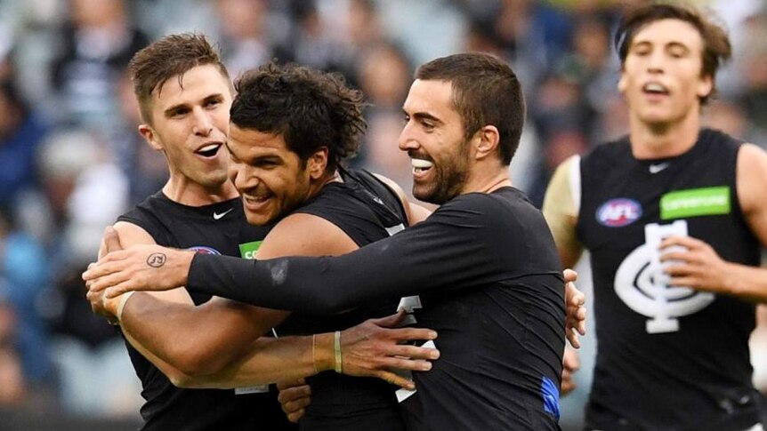 Sam Petrevski-Seton celebrates with teammates after kicking a goal for Carlton