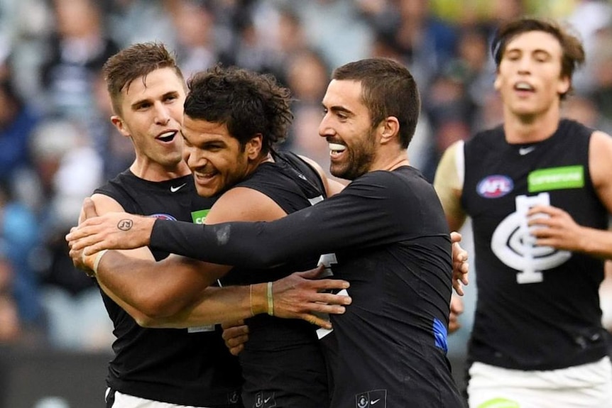 Sam Petrevski-Seton celebrates with teammates after kicking a goal for Carlton