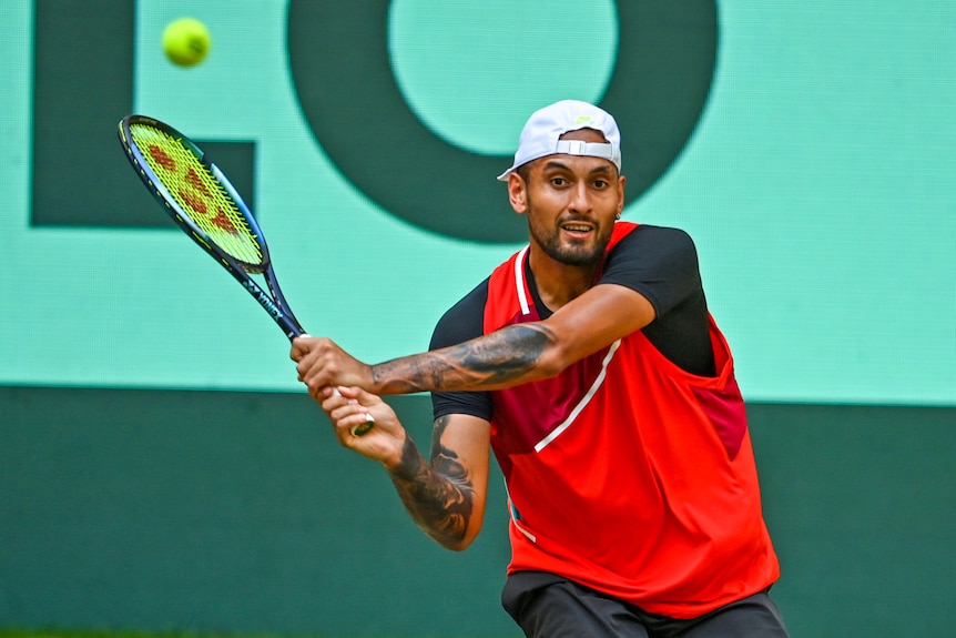 Nick Kyrgios completes his swing for a two-handed backhand from the back of the court.