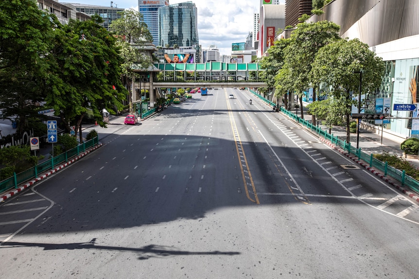The busy Ratchaprasong intersection in Bangkok lies empty on the first day of new restrictions.