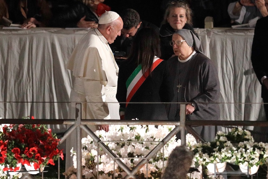 The Pope talks to a nun and a mayor on stage