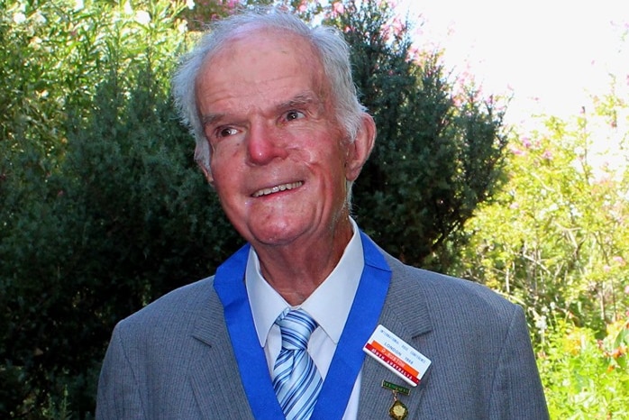 David Ruston standing in a garden with the Dean Hole medal around his neck.