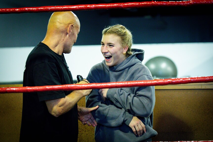 Boxing coach Kel Bryant with Marissa Williamson-Pohlman at the gym, both laughing in the ring