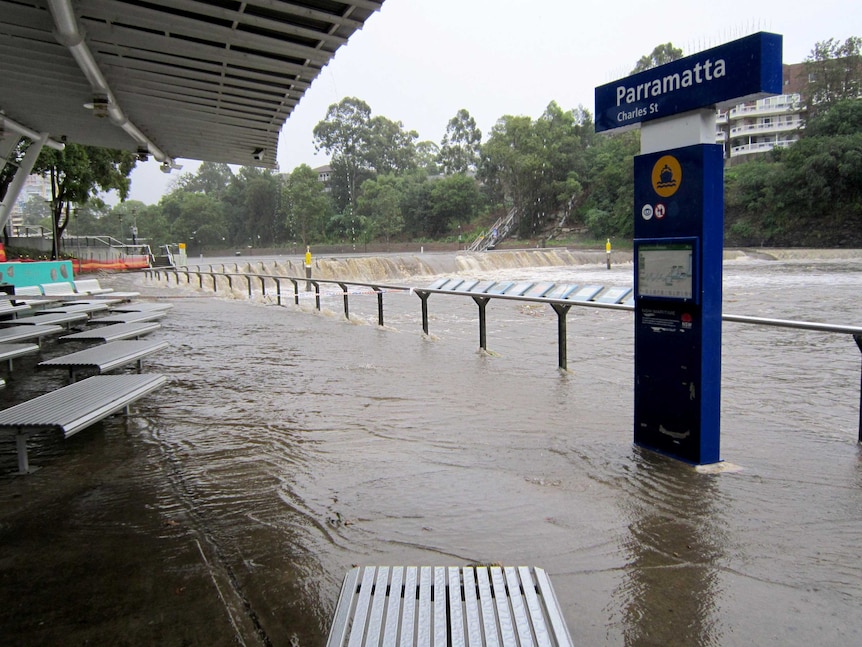 Water pours into the Parramatta River at the Parramatta Ferry Wharf during during torrential rain.