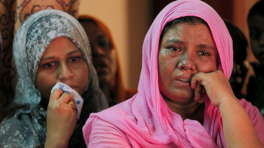 Women cry at the funeral of a Muslim man who died in a mob attack.