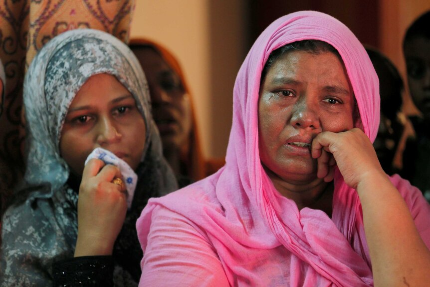 Women cry at the funeral of a Muslim man who died in a mob attack.