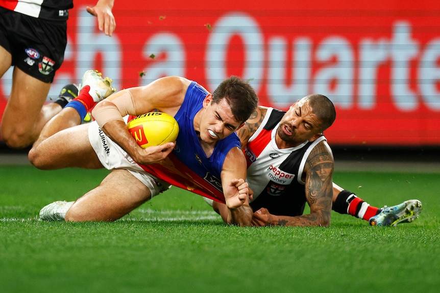 Brad Hill tackles Brandon Starcevich to the ground while he's holding the football