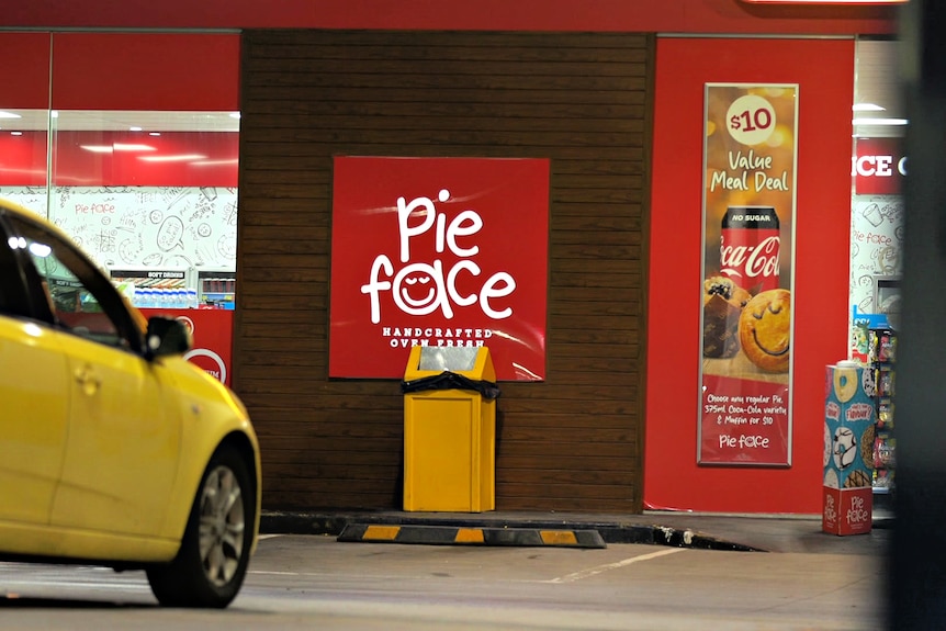 Square Pie Face sign with bin in front.