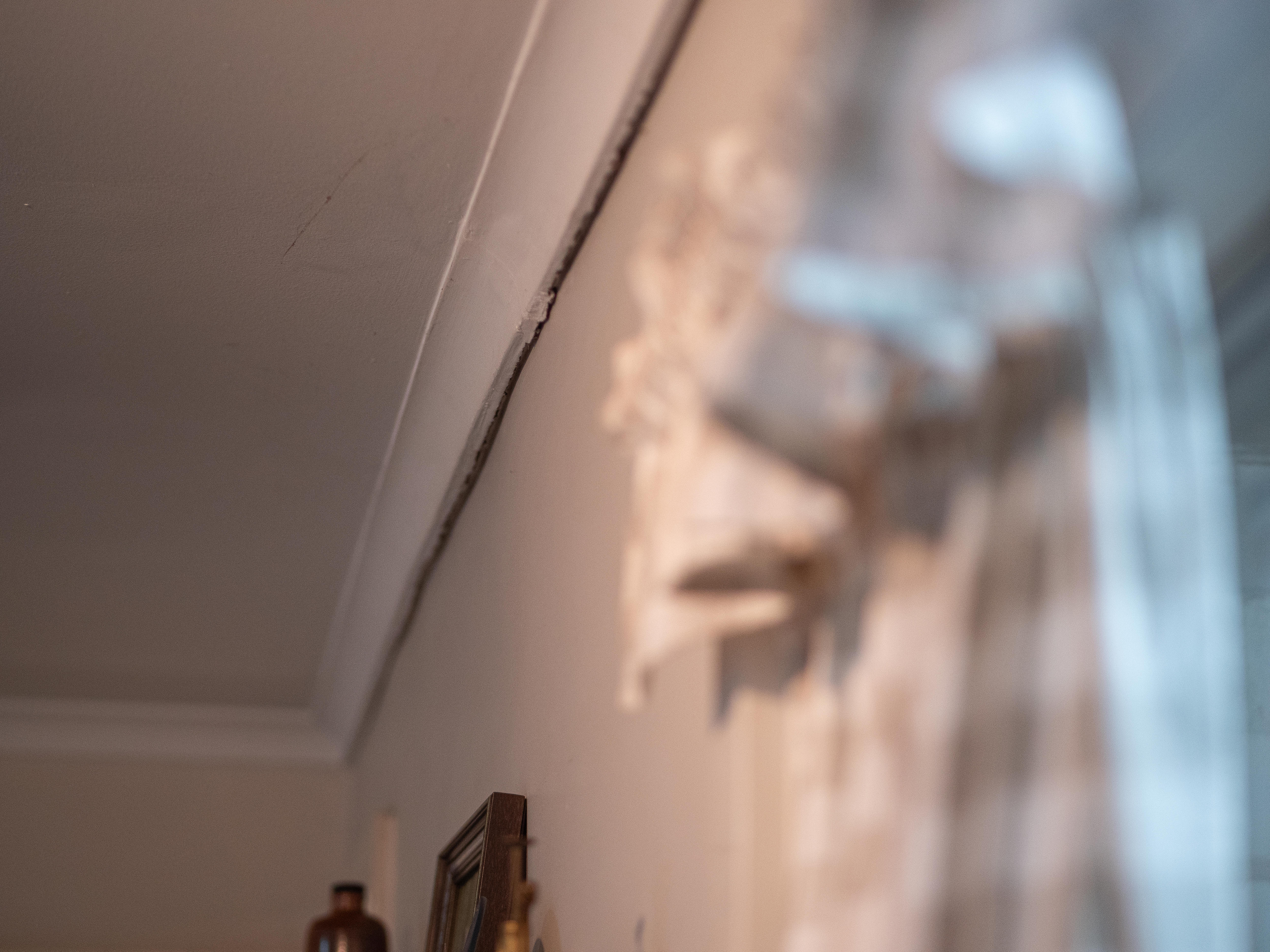 La pintura se está despegando de la pared entre la pared y el techo de una casa