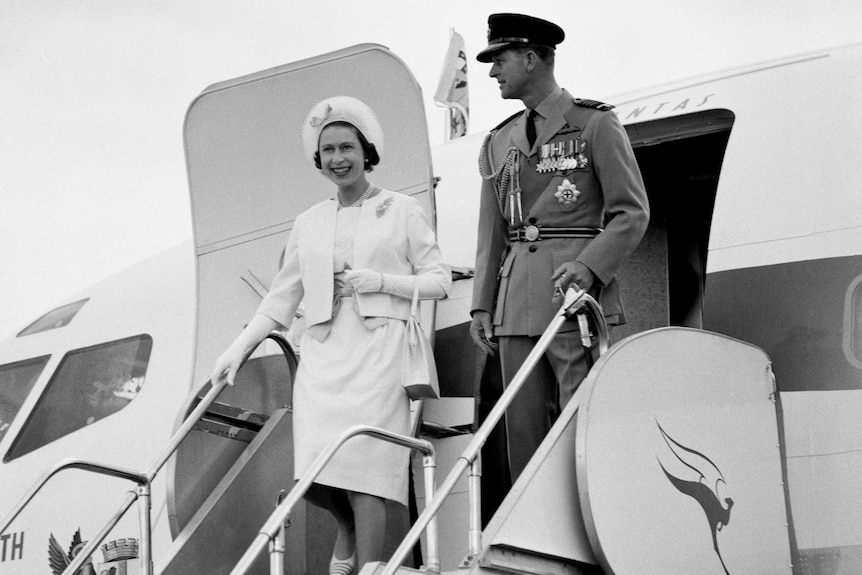 Queen Elizabeth II and the Duke of Edinburgh wave as they step off a plane, on their second visit to Australia in 1963