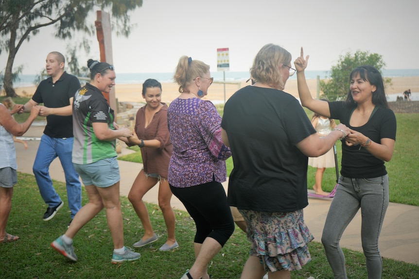 A group of people dancing in a park