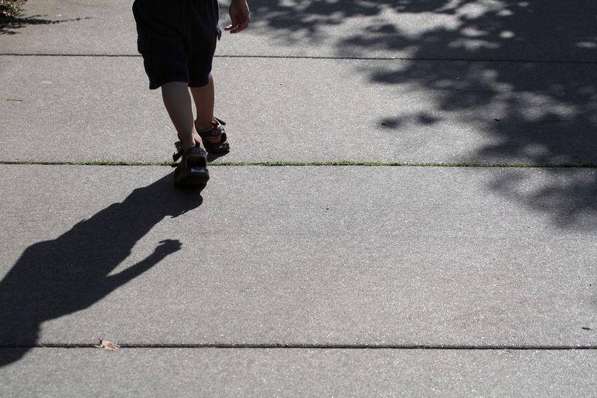 A child runs along a concrete surface.