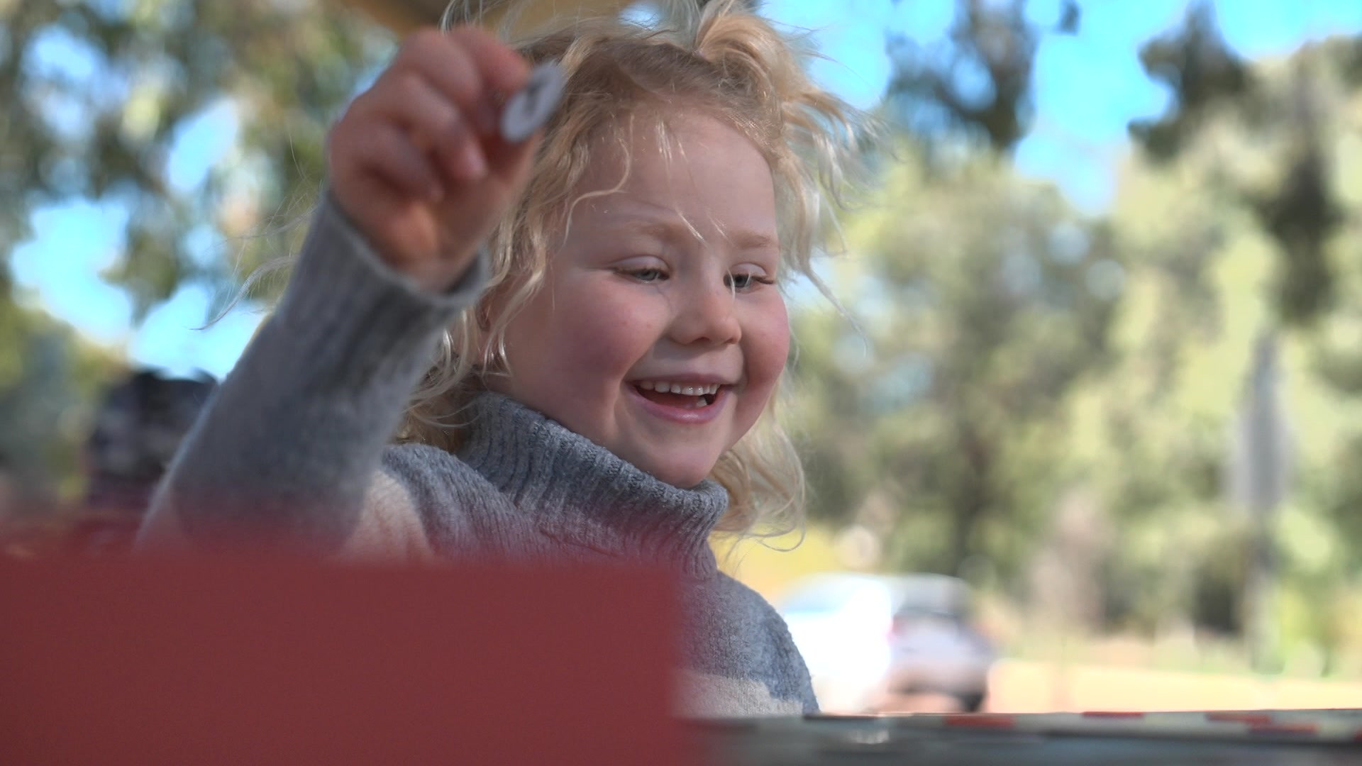 A young blonde girl plays at a table. 