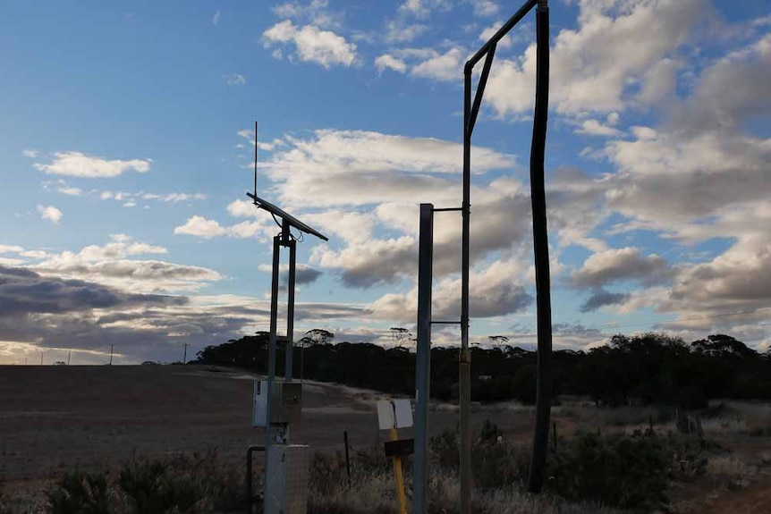 A water pipe stands next to a dry paddock.