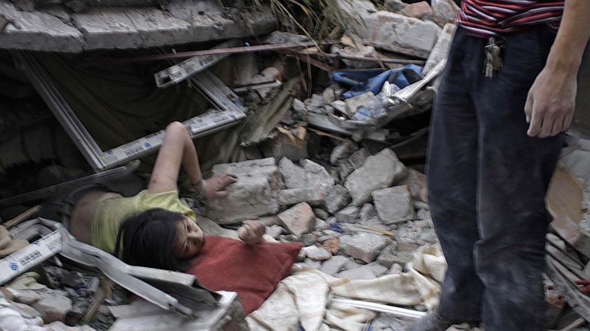 A survivor tries to escape from the debris of a collapsed building