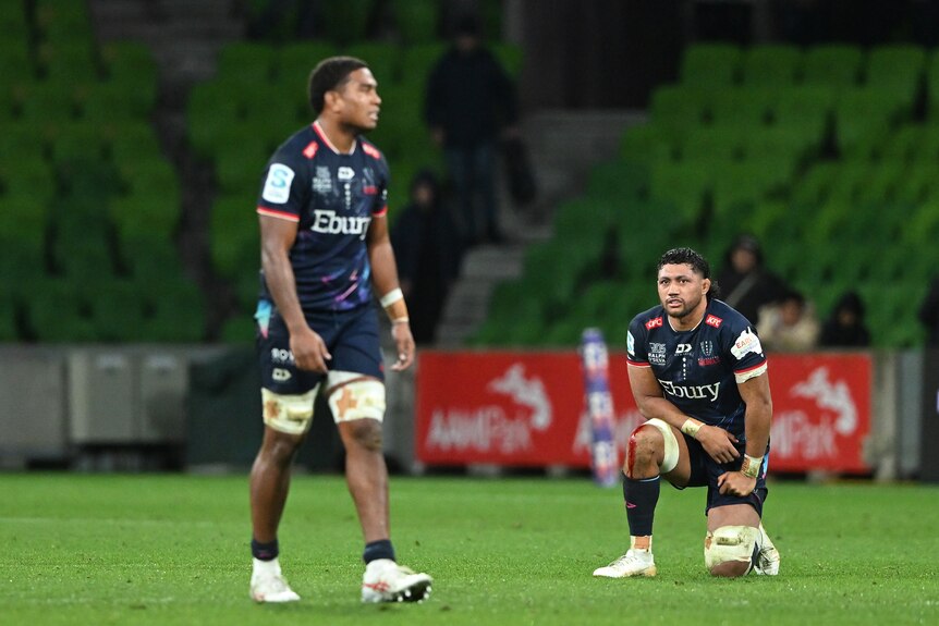 Melbourne Rebels players look upset after losing a Super Rugby Pacific match.