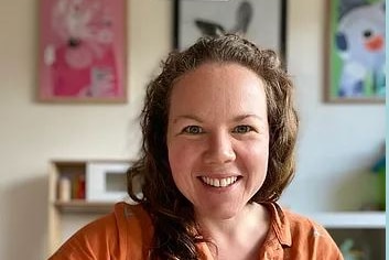 Emma Leckenby sits at a desk with crayon poised