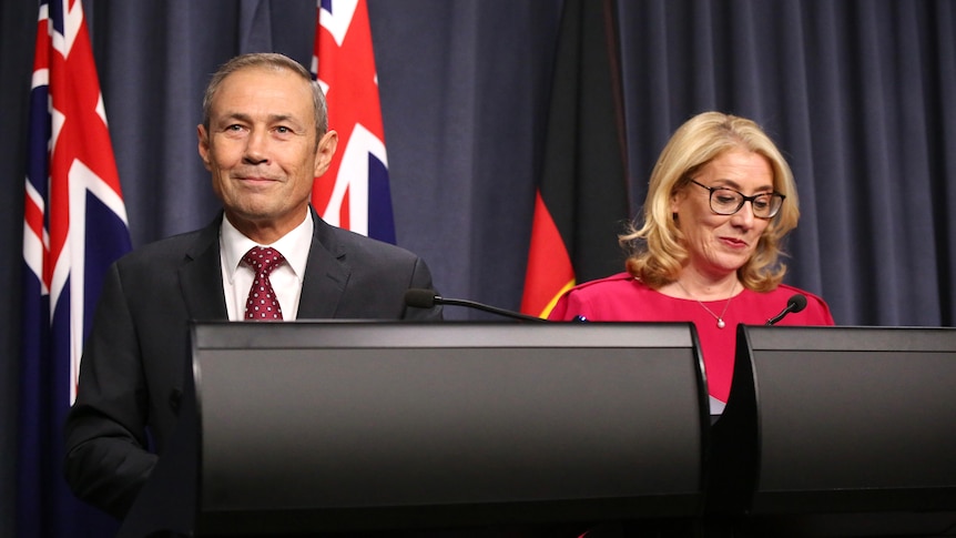 Roger Cook stands beside Rita Saffioti at the podium as they are both smiling