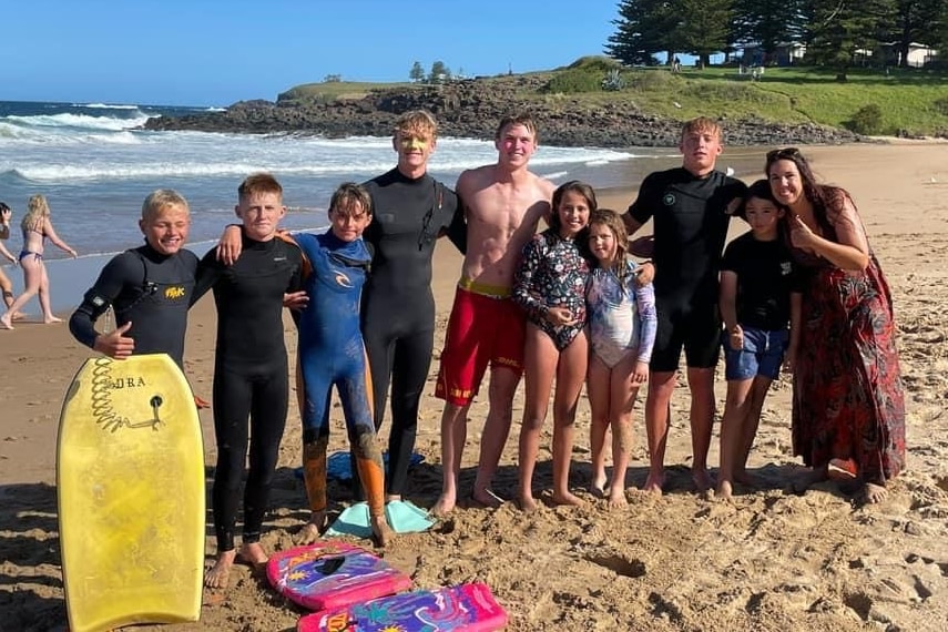 image of seven boys, two young girls and a mum on the beach