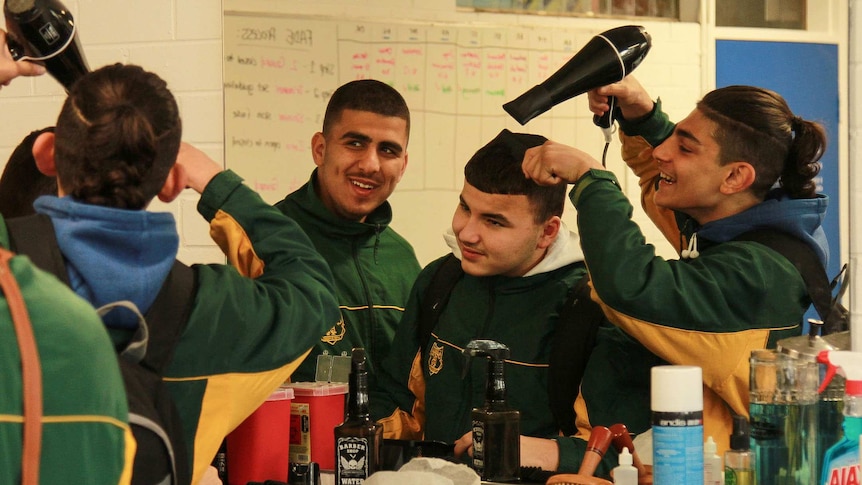 Ayman Alameddine having his hair blow-dried by another student.