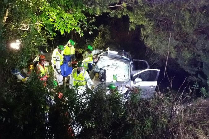 Emergency workers work to free woman from a car.