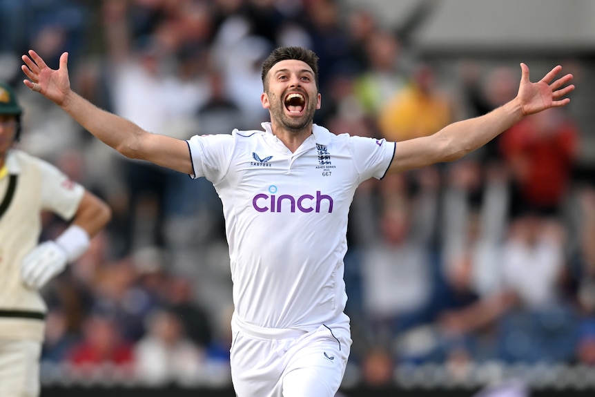 England bowler Mark Wood puts both arms out and shouts as he runs to celebrate a wicket in the Ashes.