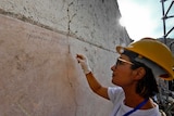 An archaeologist checks inscriptions on a wall during new excavations at the Pompeii archaeological site.