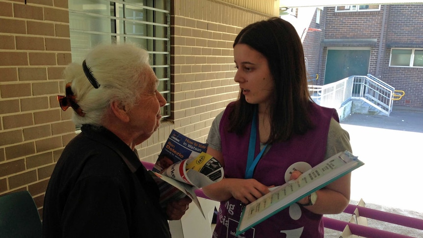 Eleni Koulouris explains the voting process to a Greek voter on election day