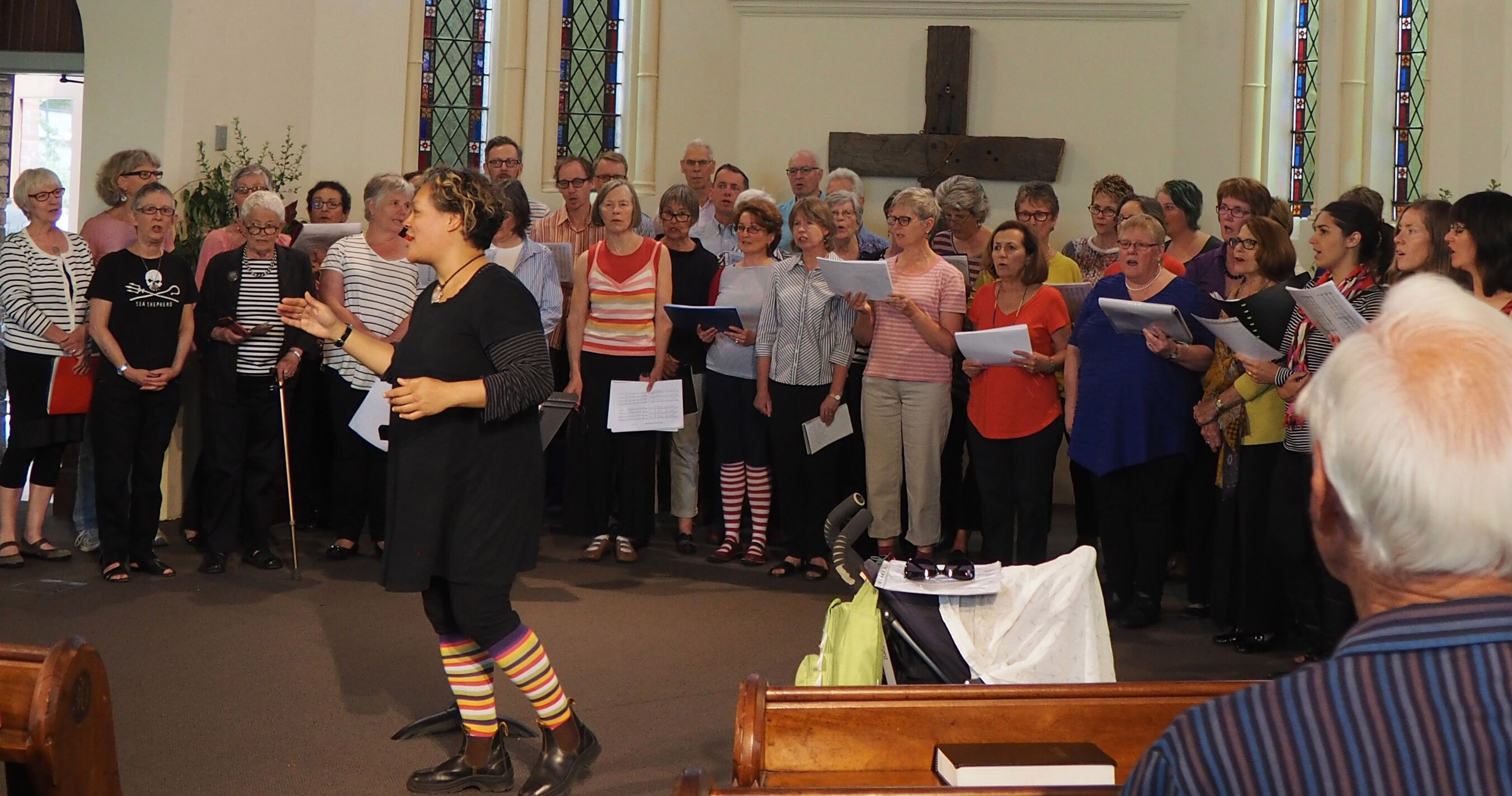 Nicky Johnson conducting a choir outside