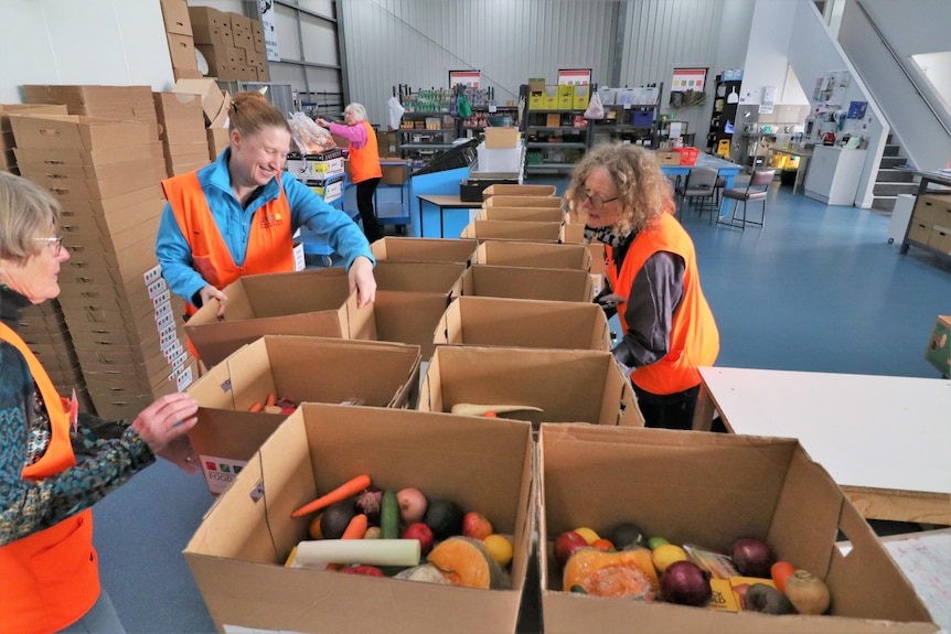 Volunteers in a warehouse with boxes of vegetables