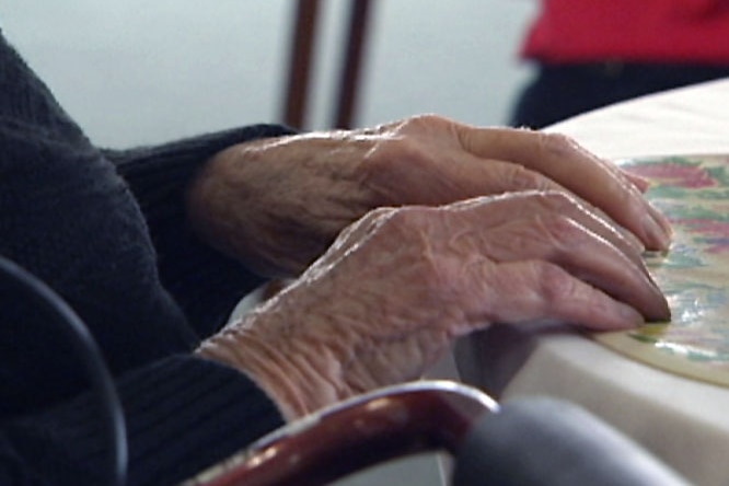 Elderly woman's hands on table.