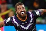 Melbourne Storm player Kenny Bromwich throws the ball while celebrating a try during an NRL clash with the Brisbane Broncos.