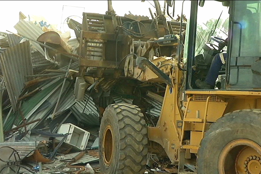 A bulldozer piles up scrap metal waste for recycling.