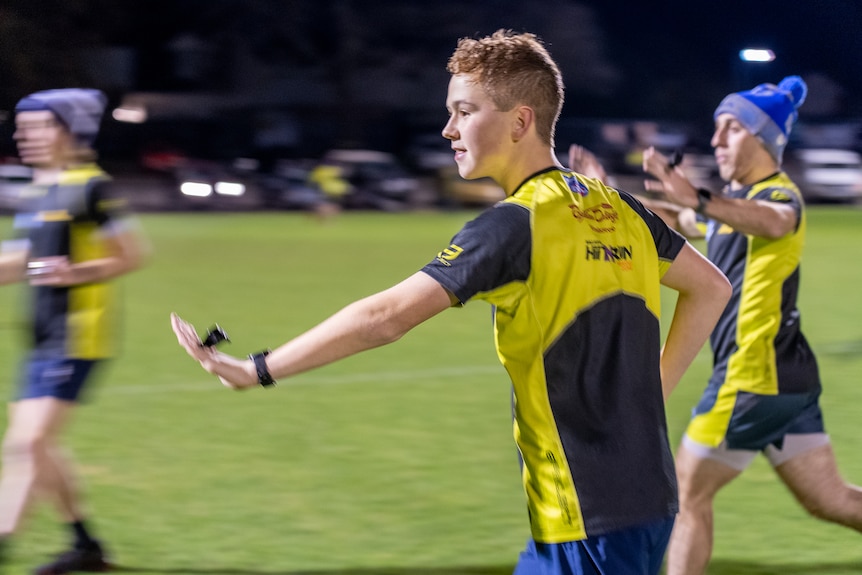 a young man running on a field.