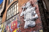 An artwork in Melbourne's AC/DC depicting Bon Scott bursting through a brick wall.