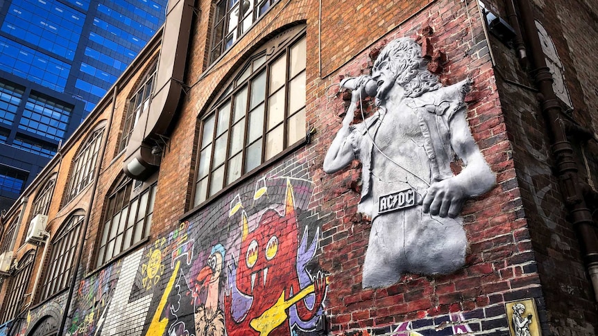 An artwork in Melbourne's AC/DC depicting Bon Scott bursting through a brick wall.