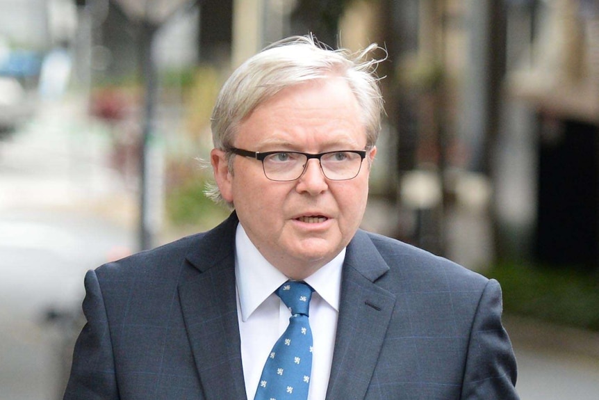 Kevin Rudd walks outside court with a briefcase in hand.