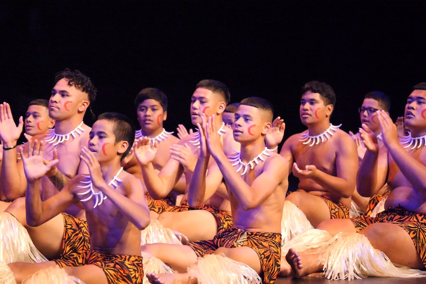 Young, shirtless boys wearing traditional Samoan necklace and sarongs, with painted faces