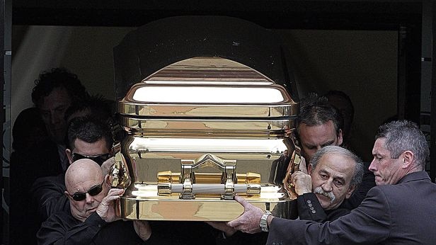 Pallbearers carry Carl Williams' golden casket from the church after his funeral on April 30, 2010.